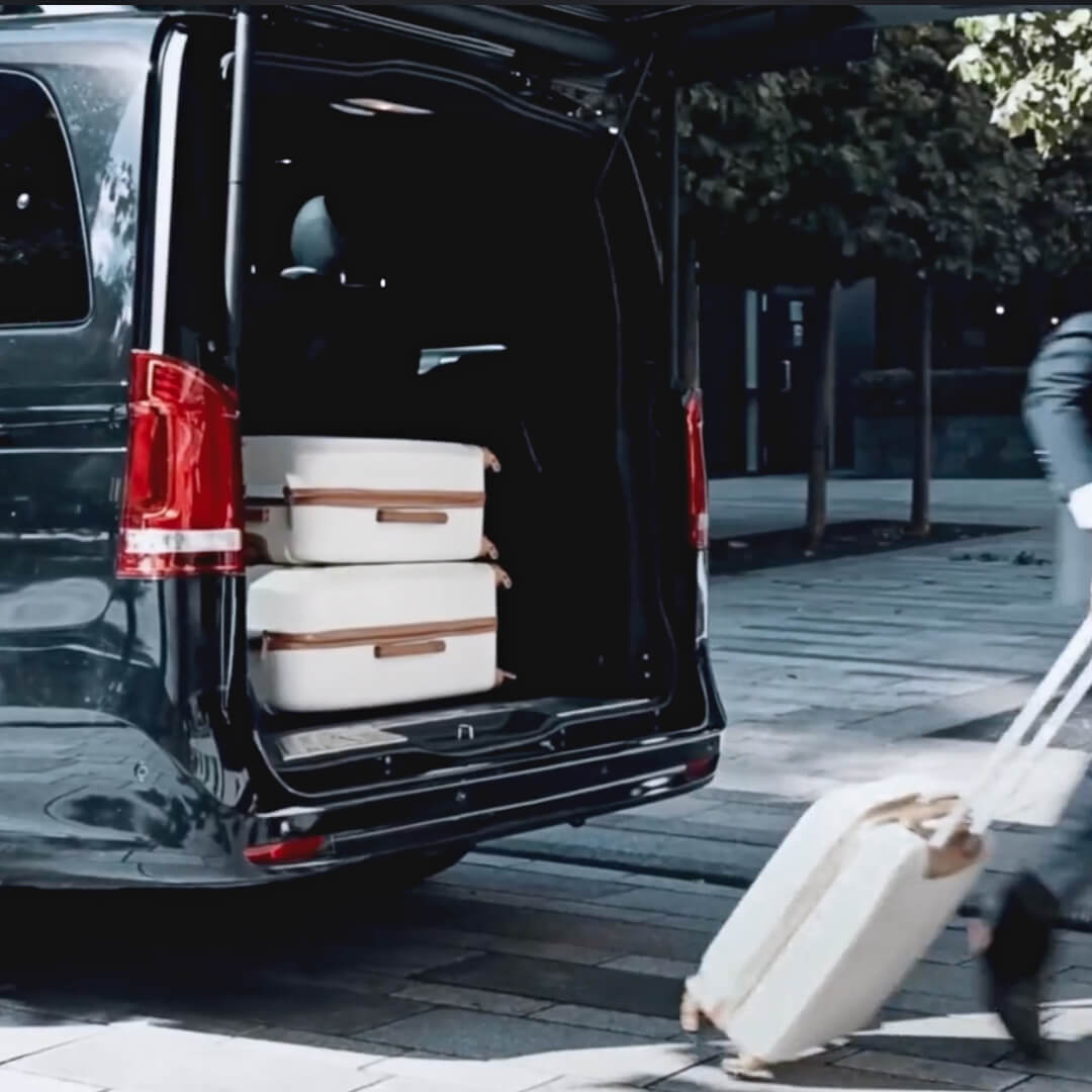 chauffeur removing luggage from the rear of a Mercedes-Benz V Class.