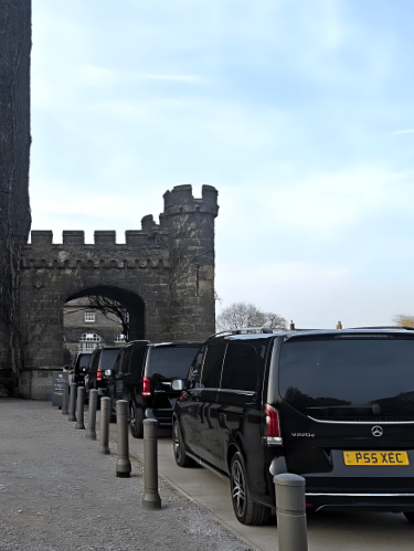Convoy of Mercedes-Benz V Class MPVs approaching a hotel event venue in Ripon.